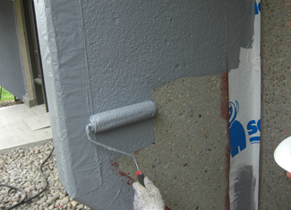main-roule-membrane-liquide-grise-avec-rouleau-resiflex-victoriaville
