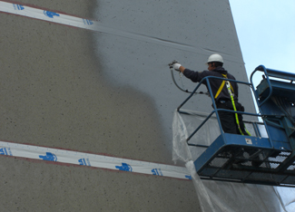 specialiste-dans-une-nacelle-appliquant-membrane-liquide-grise-sur-facade-batiment-commercial-resiflex-mauricie