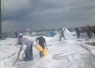 equipe-installe-grande-membane-blanche-sur-tres-grand-toit-plat-resiflex-warwick