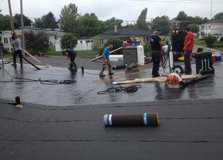 equipe-installe-membrane-elastomere-sur-couverture-de-toit-plat-resiflex-trois-riviere